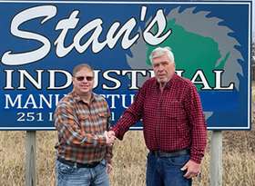 pic of Troy and George standing in front of Stan's Industrial Manufacturing sign